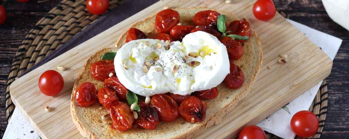 L'idea per una cena veloce e gustosa: Bruschettone con pomodorini al forno, burrata e pinoli