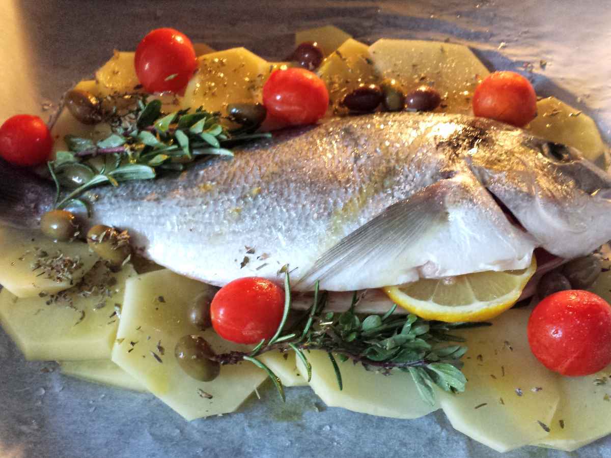 Orata al forno con patate, ciliegini, olive nere ed erbette
