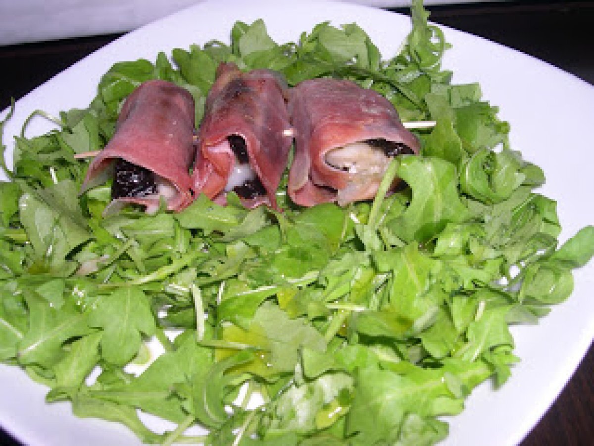 Antipasti di prugne ripiene di gorgonzola e avvolte nello speck