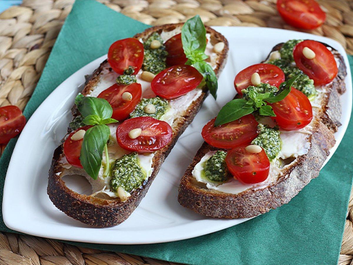 Bruschette con formaggio fresco, pesto, pinoli e pomodorini