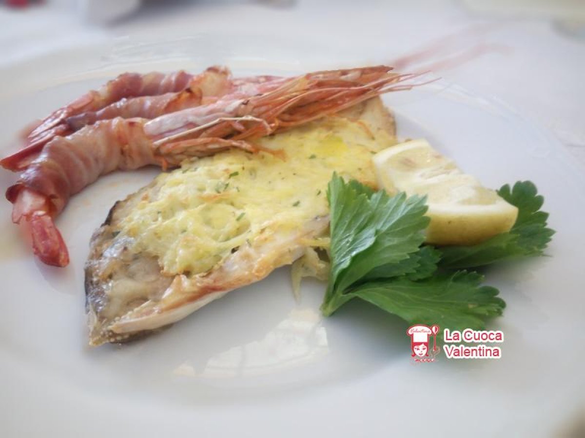 Filetto di orata al forno in crosta di patate con code di gamberi avvolti nello speck
