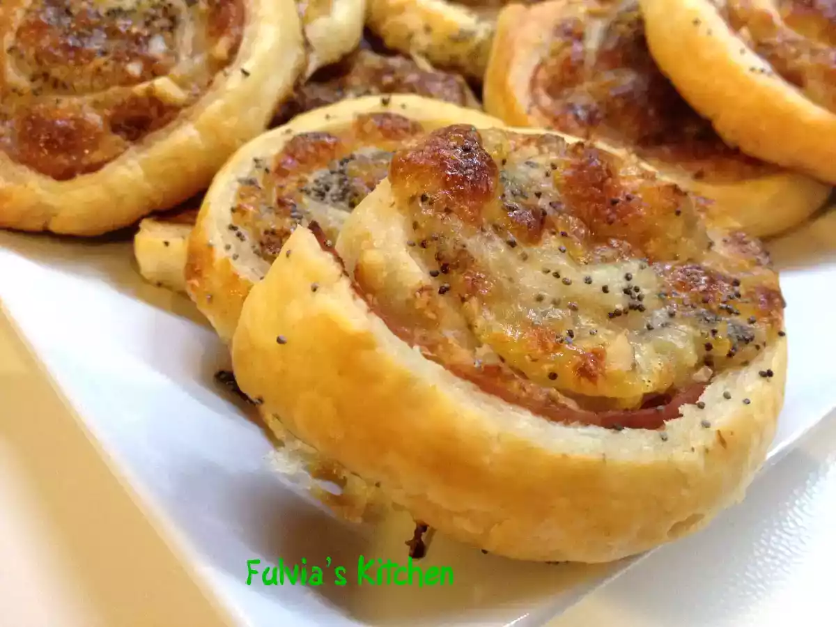 Girelle di pasta sfoglia con prosciutto cotto, mozzarella e noci