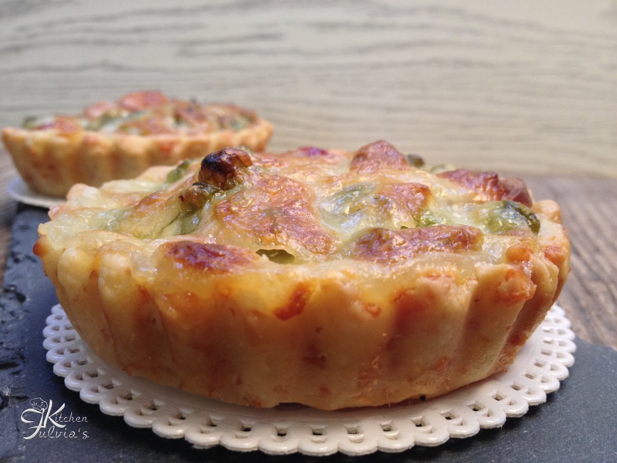 Mini quiche di frolla salata con piselli, wurstel e mozzarella