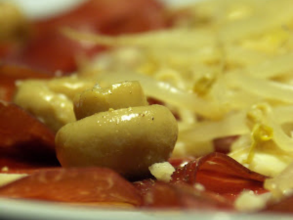 Piatto di bresaola con germogli di soia croccanti, champignons e briciole di grana