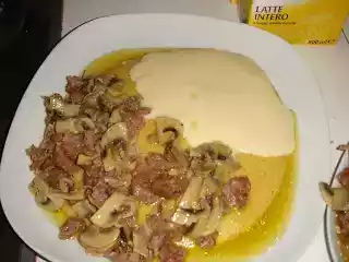Polenta con formaggio fuso, funghi e sasiccia