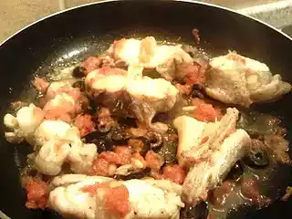 Rana pescatrice con pomodori.olive nere e pinoli con contorno di patate croccanti al rosmarino