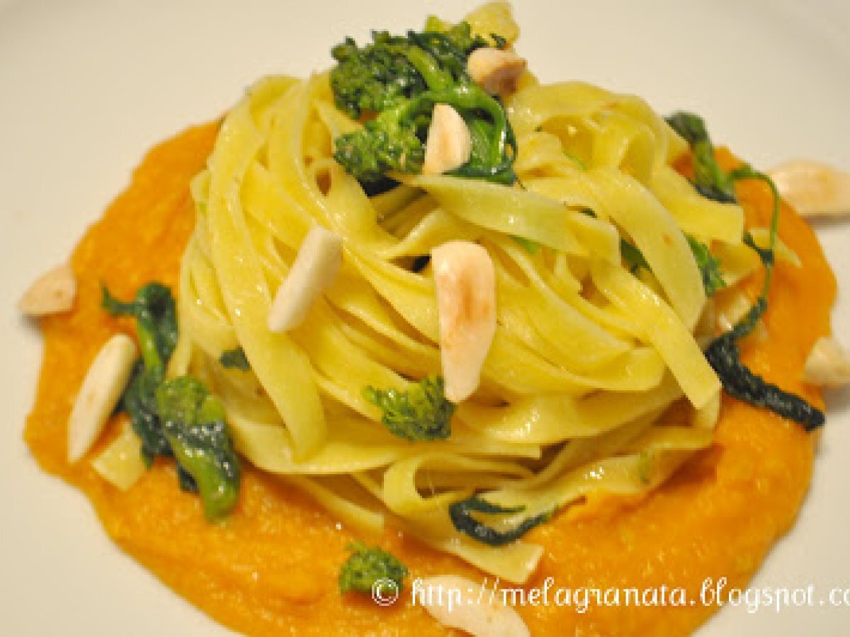 Tagliatelle allo zafferano su salsa di zucca, con cime di rapa e mandorle.