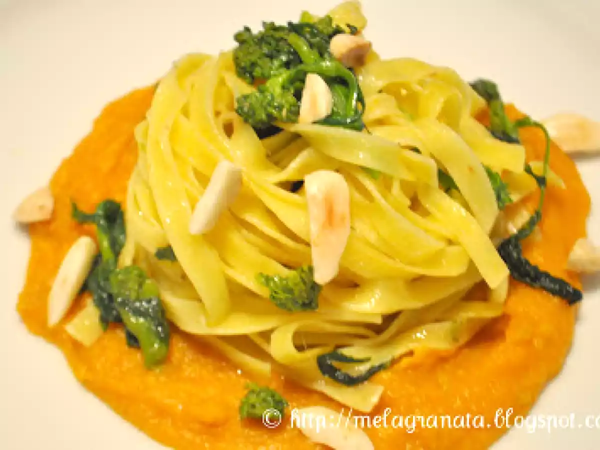 Tagliatelle allo zafferano su salsa di zucca, con cime di rapa e mandorle.