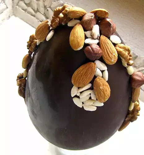 Uovo di pasqua decorato con frutta secca e cereali